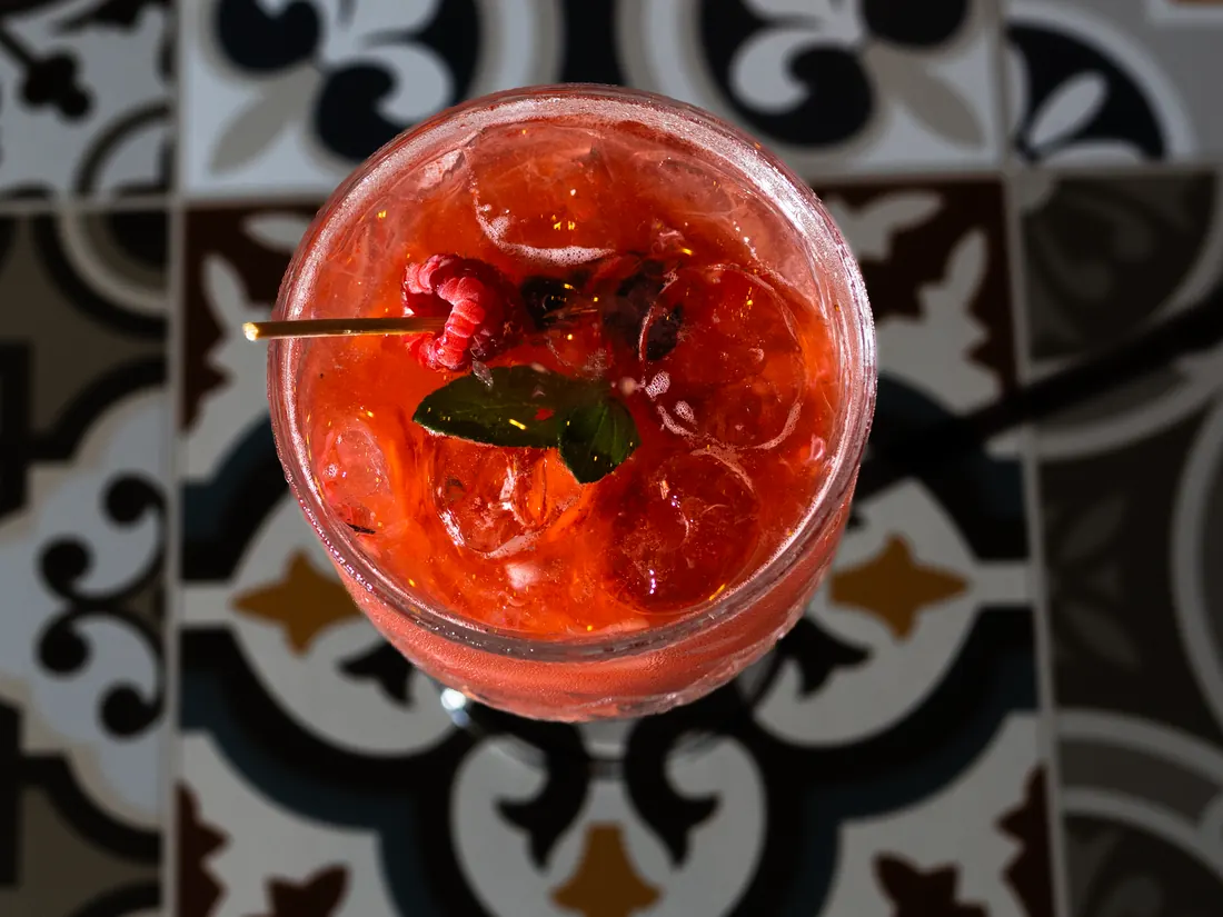 Coctel de frutos rojos sobre mesa de azulejo