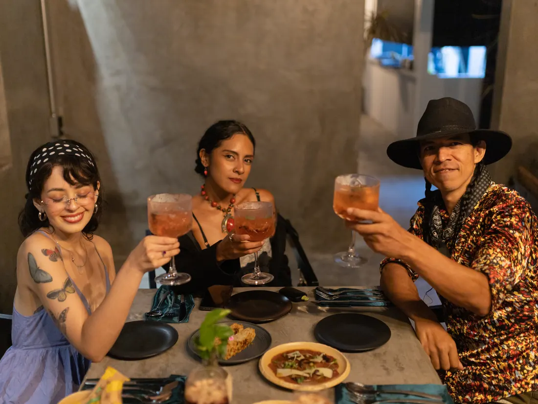 Grupo de amigos brindando con cocteles en una mesa