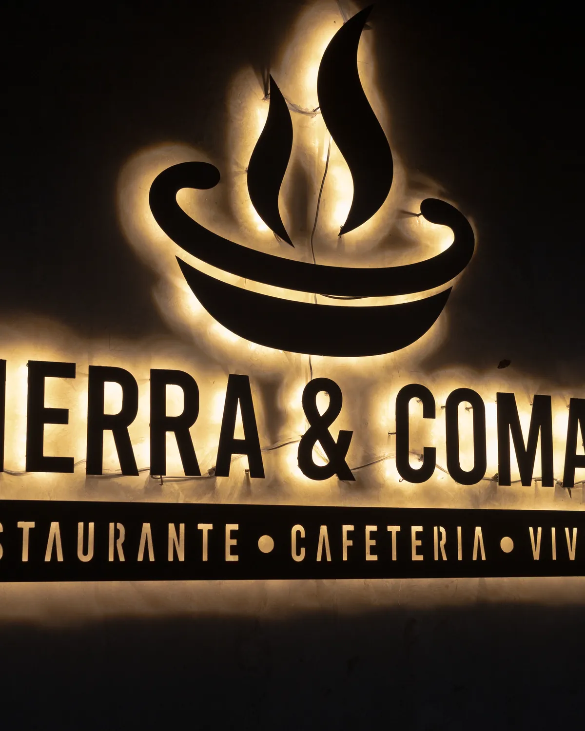 El letrero iluminado de Tierra y Comal por la noche